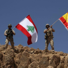 Dos soldados ondean las banderas libanesa y española tras recuperar parte de la región de Ras Baalbek.-HANDOUT (AFP)