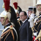 Hollande, rodeado de guardias, mientras espera la llegada del primer ministro finlandés, en el Elíseo, este miércoles.-AP / KAMIL ZIHNIOGLU