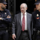 Rato, flanqueado por dos policías tras el registro de su despacho, el pasado 17 de abril.-Foto: ARCHIVO/ JOSÉ LUIS ROCA