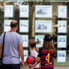 Una familia delante de una oficina inmobiliaria.-FERRAN NADEU