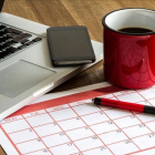 Ordenador portátil y calendario mensual.-123RF