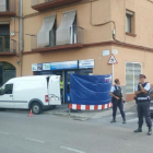 Agentes de los Mossos custodian la puerta de un locutorio de Ripoll registrado en relación con los atentados de Barcelona y Cambrils.-GERARD VILA (ACN)