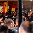Policías nacionales, en la entrada del hotel de Pineda en el que están alojados, se enfrentan a los ciudadanos que protestan fuera.-ALBERT GEA (REUTERS)