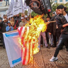 Manifestantes palestinos queman banderas de EEUU e Israel en Gaza.-AFP / MAHMUD HAMS