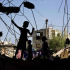 Unos niños palestinos juegan en las ruinas de un edificio destruido.-Foto: AFP/ MOHAMMED ABED