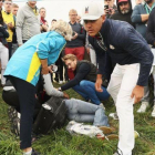 La espectadora de la Ryder, atendida en el suelo, tras un golpe de Brooks Koepka.-EL PERIÓDICO