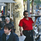 Un camarero trabajando en una terraza de un bar.-RICARD CUGAT (EL PERIÓDICO)