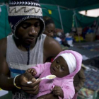 Un extranjero alimenta a su bebé en una tienda donde han sido realojados en Isibingo, en el sur de Durban, este lunes.-Foto:   REUTERS / ROGAN WARD