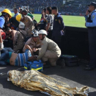 Las asistencias médicas atienden a varios heridos cerca de uno de los dos fallecidos dentro del estadio-AFP