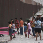 Niños juegan en un balancín situado en el muro de México a su paso por Ciudad Juarez.-AP