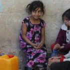 Niñas yemenís esperan para coger agua en una fuente potable en Saná.-EFE