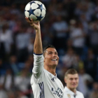 Cristiano Ronaldo luce el balón que se llevó como recompensa a los tres goles anotados ante el Bayern.-SERGIO PÉREZ