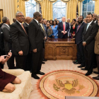 Kellyanne Conway, de rodillas y con zapatos, consulta su móvil mientras Trump y sus invitados posan para la foto oficial-AFP