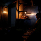 Una mujer usa la luz de una linterna para trabajar en la cocina de un restaurante tras un nuevo apagón en Caracas.-CARLOS GARCÍA RAWLINS (REUTERS)