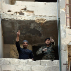 Soldados sirios en Alepo hacen la señal de la victoria.-EFE