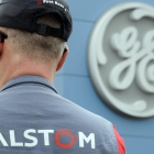 Un empleado de Alstom frente a un logo de GE, durante las negociaciones de la compra.-SEBASTIEN BOZON (AFP)