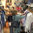 Varias personas observan la ropa expuesta en una tienda.-MARIO TEJEDOR