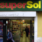 Una cliente sale de un supermercado SuperSol, en una centrica calle de Sevilla.-JULIO MUÑOZ (EFE)