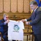 El presidente ucraniano, Petro Poroshenko, entrega una camiseta con la imagen de un cineasta encarcelado en Rusia al cantante Elton John.-EFE / MIKHAIL PALINCHAK