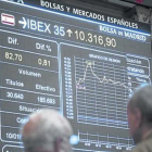 Dos inversores observan una pantalla con la evolución del Ibex 35 en la Bolsa de Madrid.-ARCHIVO / EFE