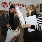 Un hombre recibe alimentos en Cáritas. / FERNANDO SANTIAGO-