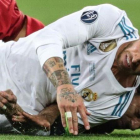 Sergio Ramos cae sobre Salah tras la disputa de un balón y le lesiona.-EFE / ARMANDO BABANI