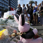 Varias personas colocan flores, velas y un peluche en tributo a las víctimas del atentado en Niza, este viernes.-REUTERS / PASCAL ROSSIGNOL