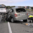 Un agente junto al coche que colisionó contra un camión en el accidente mortal.-VALENTÍN GUISANDE