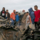 Unos palestinos permanecen junto a los restos de un automóvil destruido tras un ataque aéreo israelí en Khan Yunis, en el sur de la Franja de Gaza.-SAID KHATIB (AFP)