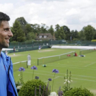 Djokovic observa las pistas de Wimbledon tras el entrenamiento del domingo.-AP / BEN CURTIS