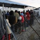 Refugiados y migrantes hacen cola durante la distribución de comida en un campamento cercano a Idomeni, en la frontera de Grecia con Macedonia, este jueves.-REUTERS / YANNIS BEHRAKIS