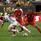 El colombiano James Rodriguez pugna por el balón con los peruanos Alberto Rodriguez y Miguel Trauco.-EFE / JASON SZENES