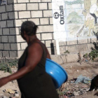 Dos mujeres pasan ante un mural de Oxfam en Puerto Príncipe, Haití.-ANDRES MARTINEZ CASARES (REUTERS)