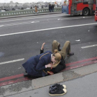 Una mujer atiende a un herido en el puente de Londres.-REUTERS / TOBY MELVILLE