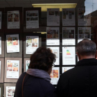 Una pareja mira los anuncios de una inmobiliaria en Valladolid.-ICAL