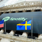 El logo de Spotify cuelga de la fachada de la Bolsa de Nueva York entre la bandera de Estados Unidos y la Sueca, país en el que la plataforma número uno de música en internet fue fundada y tiene su sede.-/ HANDOUT (REUTERS)