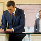 Pedro Sánchez firma el acuerdo presupuestario ante la mirada de Pablo Iglesias, en la Moncloa-JOSÉ LUIS ROCA