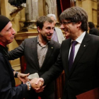 El 'president' Puigdemont saluda a Lluís Llach en el Parlament.-JOAN CORTADELLAS