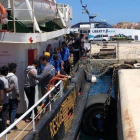 Varios inmigrantes rescatados en alta mar se disponen a desembarcar en el puerto italiano de Lampedusa.-ELIO DESIDERIO (EFE)