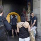 Varias personas esperan para operar en un cajero de una oficina de CaixaBank en la plaza de Catalunya.-ALBERT BERTRAN