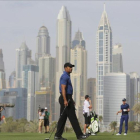 Woods, en un momento de su recorrido, con el 'skyline' de Dubai al fondo.-KAMRAN JEBREILI / AP