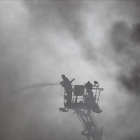Un bombero trabaja en el lugar del incendio, una fábrica de embalajes de cuatro plantas.-AP
