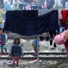Niños refugiados juegan entre ropas colgadas para secar entre alambradas en un campo de refugiados de Idomeni (Grecia), junto a la frontera con Macedonia, este miércoles.-AP / BORIS GRDANOSKI
