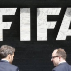 Dos hombres pasan por delante de la sede central de la FIFA en Zúrich.-Foto: AP / MICHAEL PROBST