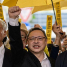 De izquieda a derecha, Chu Yiu-ming, Benny Tai y Chan Kin-man, saludan a su seguidores antes de entrar en el tribunal de West Kowloon en Hong Kong.-AFP / ANTHONY WALLACE