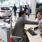 Un cliente de un concesionario de coches pide información.-EL PERIÓDICO