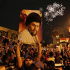 Un seguidor de Moqtada al Sadr sostiene una foto del clérigo en una concentración en la plaza Tahrir de Bagdad para celebrar el resultado electoral.-/ AP / HADI MIZBAN