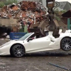El Ferrari 458 Spider siendo destrozado por una grúa en un desguace.-/ HOTSPOT MEDIA