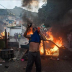 Un grupo de personas se manifiesta en una calle de Carcas (Venezuela).-MIGUEL GUTIERREZ (EFE)