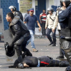 Uno de los policías yace en el suelo justo después de ser arrollado por le autobús.-REUTERS / CARLOS EDUARDO RAMIREZ
